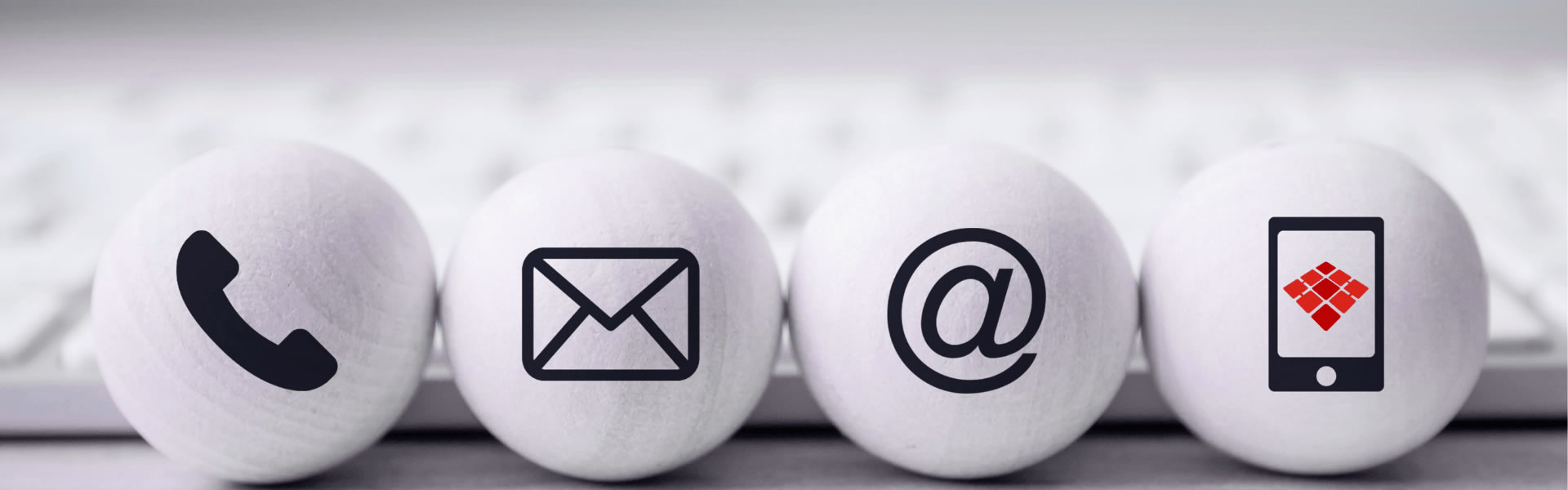 fundo de teclado e quatro circulos, em cada um com um simbolo, o primeiro telefone, o segundo envelope, terceiro um @ e o terceiro celular com imagem do simbolo da LANSIS de fundo