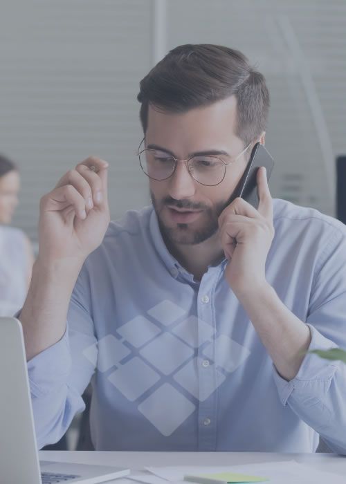 Homem freight forwarder negociando ao telefone com cliente em ambiente logístico, destacando interação comercial e gestão de transporte.